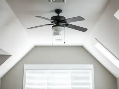 A properly installed black ceiling fan with a light fixture is centered